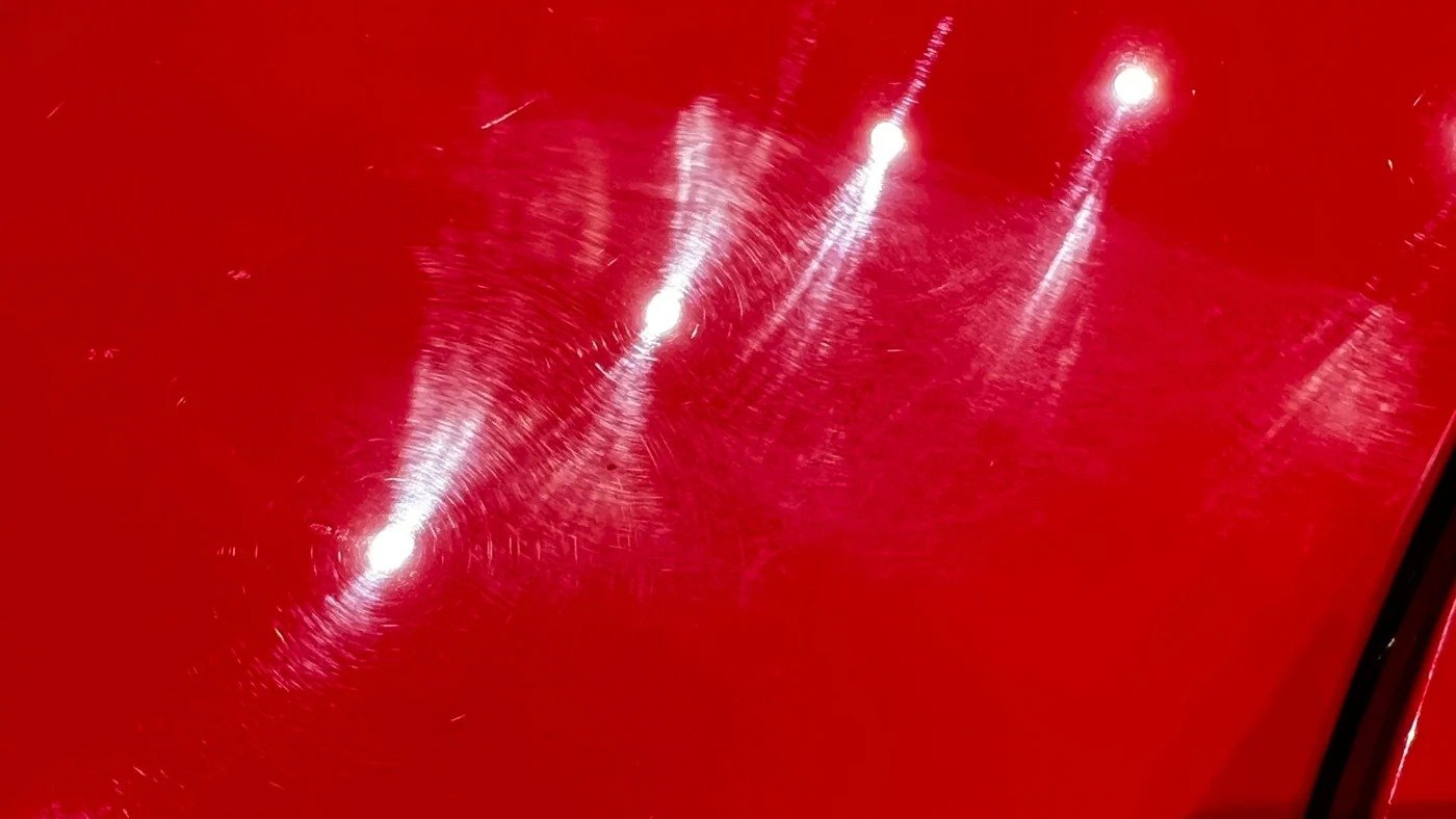 Superficie roja antes del pulido, con marcas circulares visibles.